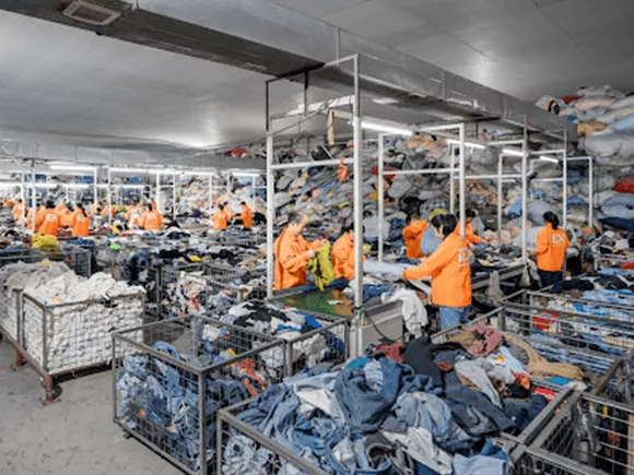 Equipo de Indetexx clasificando ropa usada en líneas de trabajo
